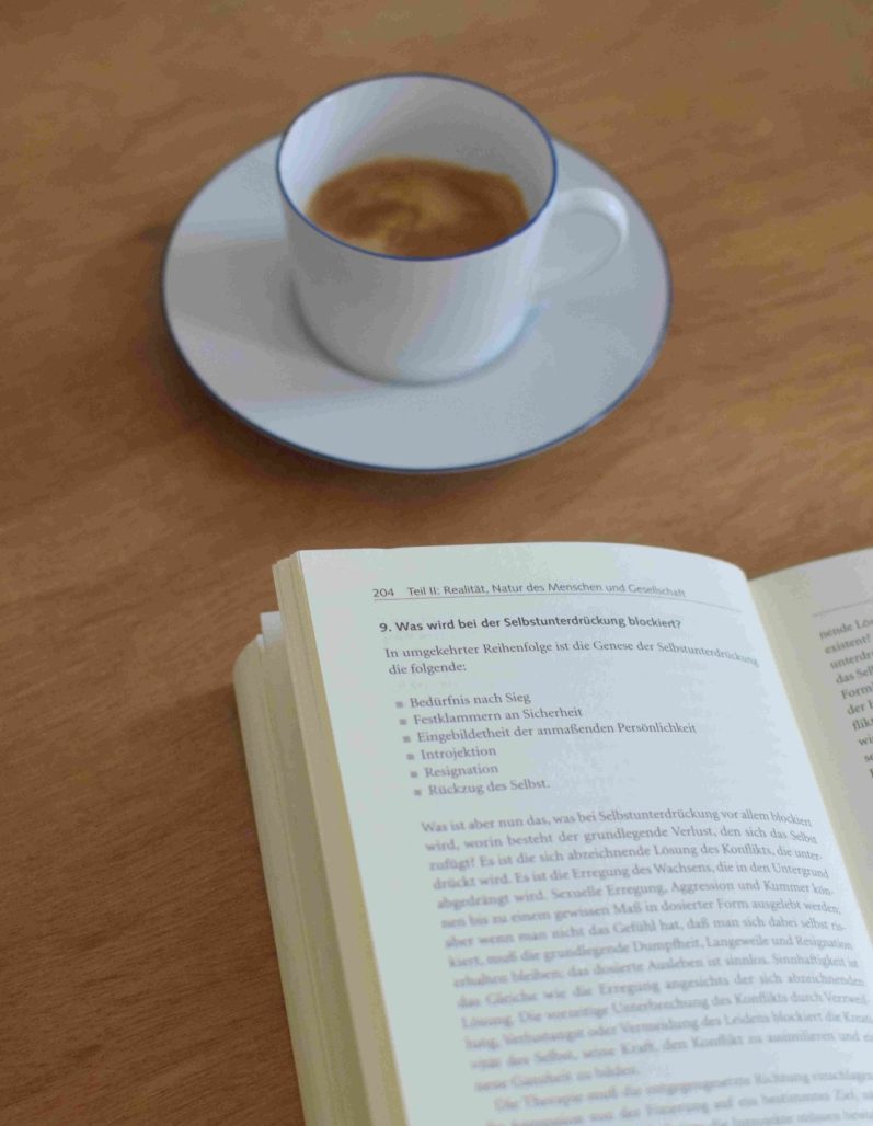 Themen und Gründe für Therapie und Coaching, Motivation Kaffeetasse und Psychotherapiebuch für Fachwissen und Qualifikation